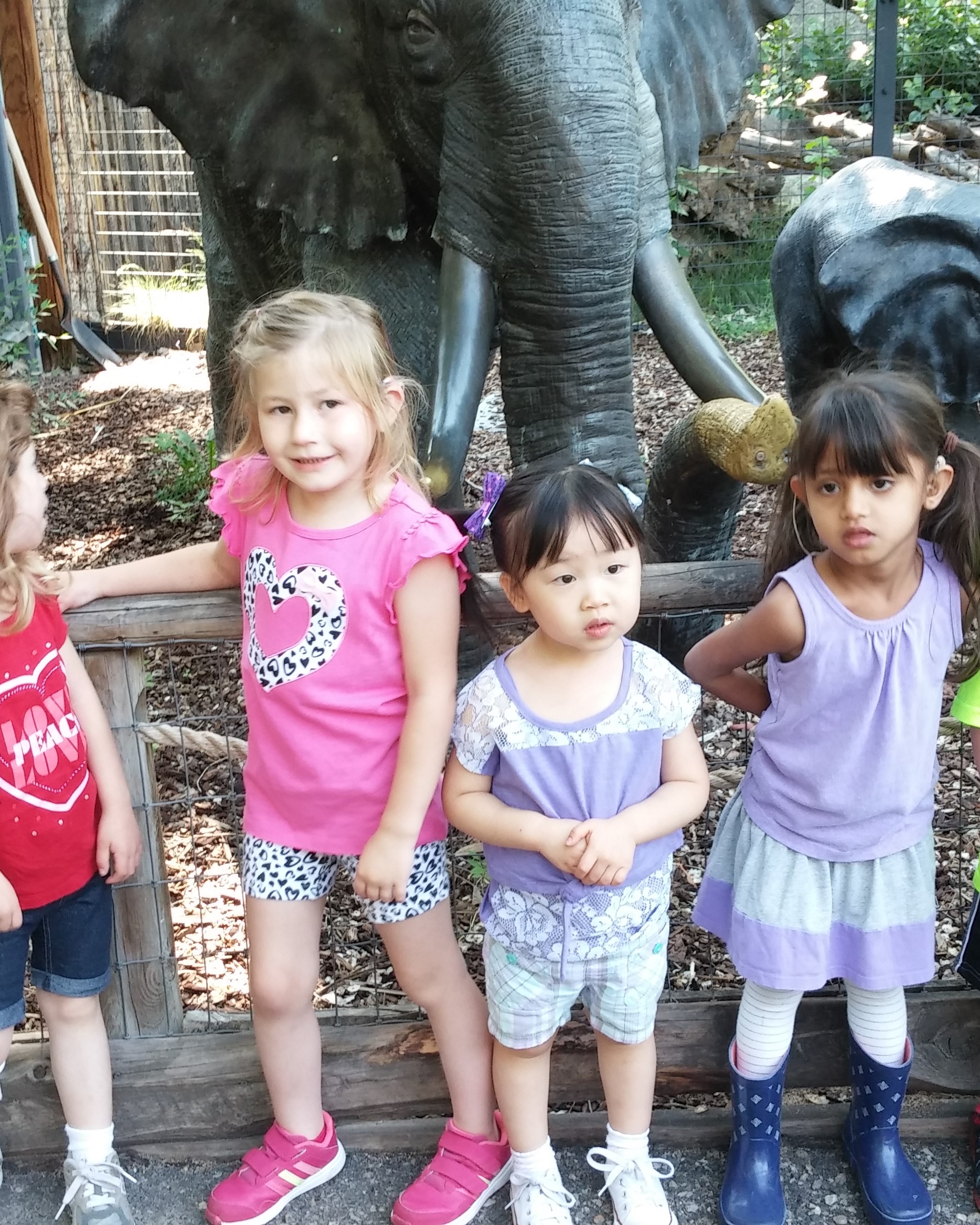 pre-school children posing in front of elephant statue